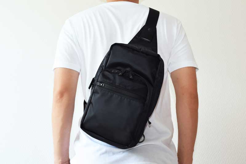 ボディバッグを背中にかけている男性の画像
